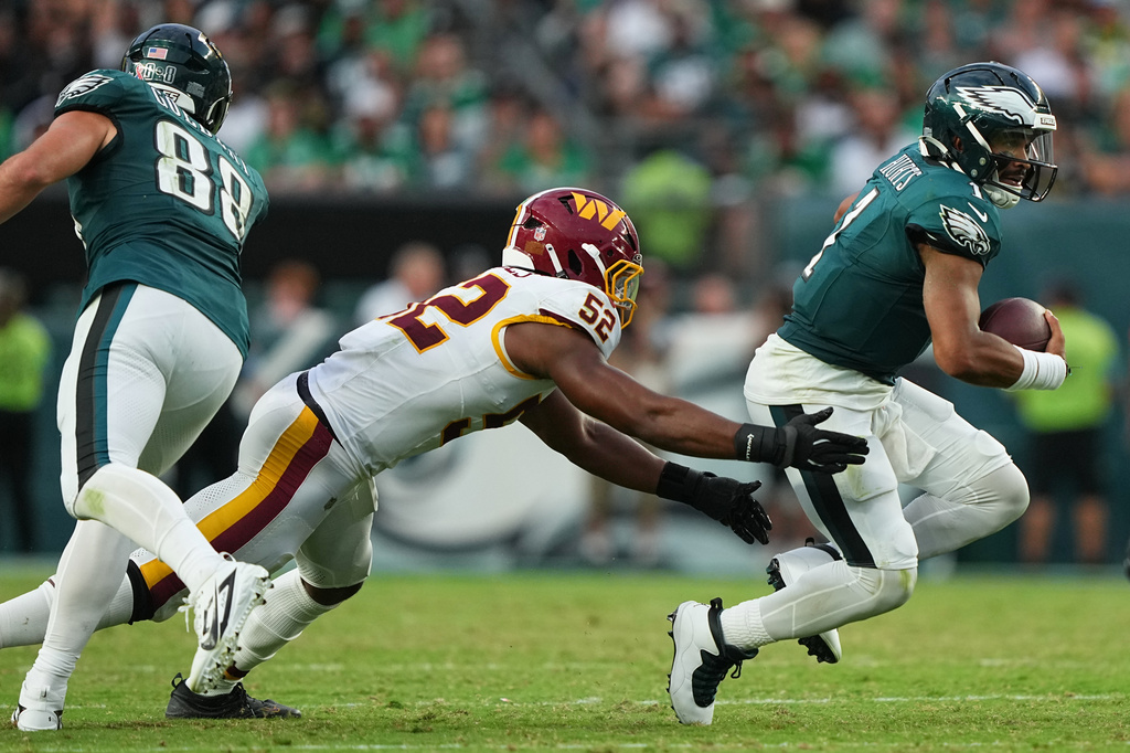 Philadelphia Eagles quarterback Jalen Hurts (1) runs from Washington Commanders linebacker Sonny Styles (52) during the second half of an NFL football game, Sunday, Sept. 13, 2026, in Philadelphia. (AP Photo/Matt Rourke)