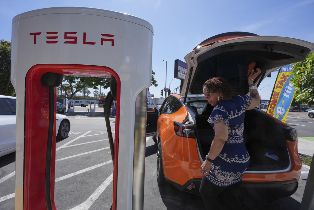 FILE - Janelle Lowe prepares to charge her electric vehicle at a station May 22, 2025, in Long Beach, Calif. (AP Photo/Damian Dovarganes, File)