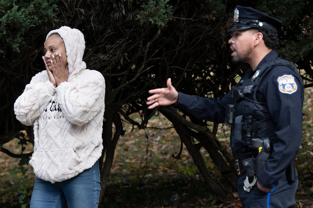 An unidentified family member of 23-year-old Kada Scott talks to police in Germantown, Pa., Wednesday, Oct. 15, 2025, near an abandoned school as police continue to investigate Scott's disappearance. (Jose F. Moreno/The Philadelphia Inquirer via AP)