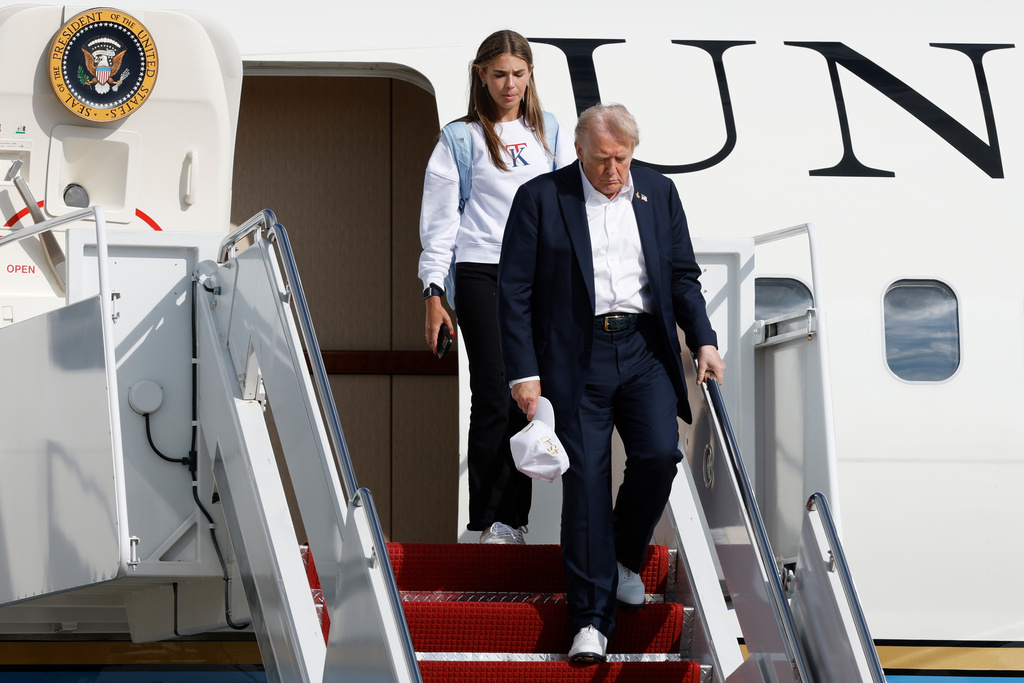 President Donald Trump, front right, walks down the stairs of Air Force One with his granddaughter Kai Trump upon arriving at Joint Base Andrews, Md., Friday Sept. 26, 2025, after a day trip to the Ryder Cup golf tournament at Bethpage Black in Farmingdale, N.Y. (AP Photo/Luis M. Alvarez)