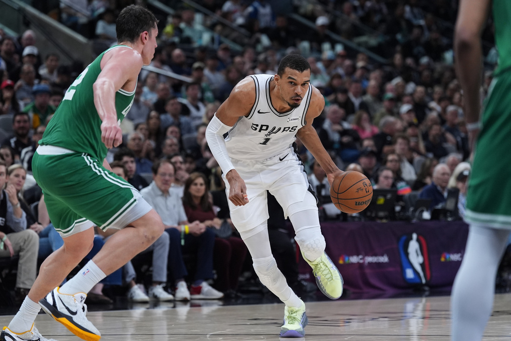 San Antonio Spurs forward Victor Wembanyama (1) drives against Boston Celtics center Luka Garza, left, during the second half of an NBA basketball game in San Antonio, Tuesday, March 10, 2026. (AP Photo/Eric Gay)