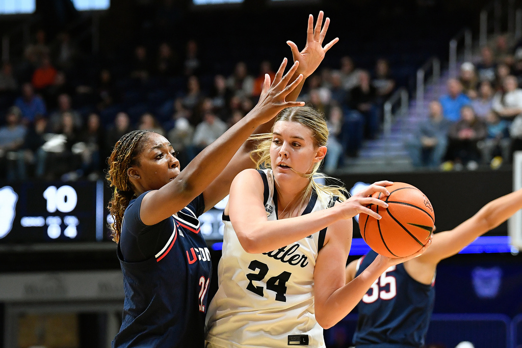 Butler forward Mallory Miller (24) attempts to pass the ball away from the pressure from UConn forward Serah Williams during the first half of an NCAA college basketball game in Indianapolis, Sunday, Dec. 28, 2025. (AP Photo/Timothy D. Easley)