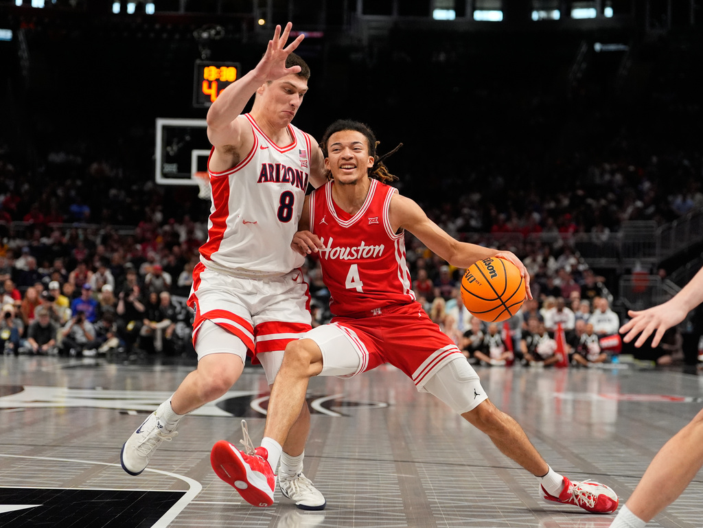 Houston's Kingston Flemings (4) drives past Arizona's Ivan Kharchenkov (8) during the first half of an NCAA college basketball game in the championship of the Big 12 Conference tournament Saturday, March 14, 2026, in Kansas City, Mo. (AP Photo/Charlie Riedel)