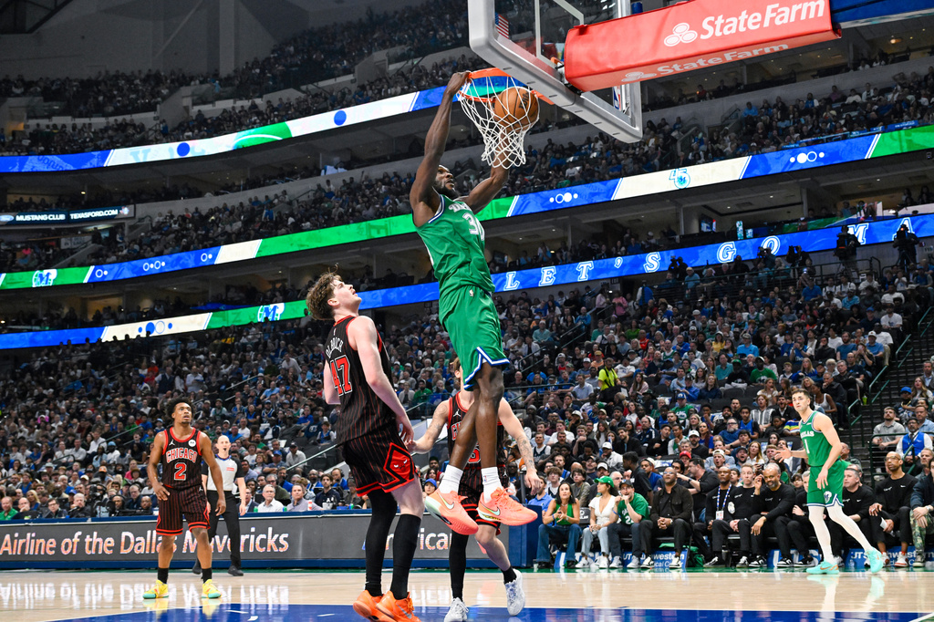Dallas Mavericks' Moussa Cisse, center top, dunks over Chicago Bulls center Lachlan Olbrich during an NBA basketball game against the Chicago Bulls, Sunday, April 12, 2026, in Dallas. (AP Photo/Albert Pena)