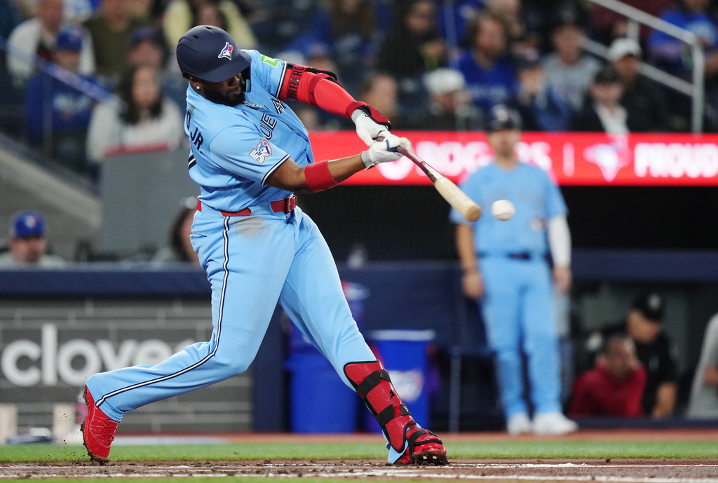 Toronto Blue Jays' Vladimir Guerrero Jr. (27) hits a single against the Colorado Rockies during the fourth inning of a baseball game in Toronto on Tuesday, March 31, 2026. (Nathan Denette/The Canadian Press via AP)