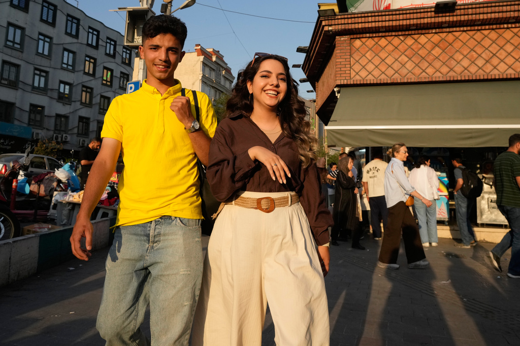 Joyful youngsters walk on a sidewalk in northern Tehran, Wednesday, June 10, 2026. (AP Photo/Vahid Salemi)