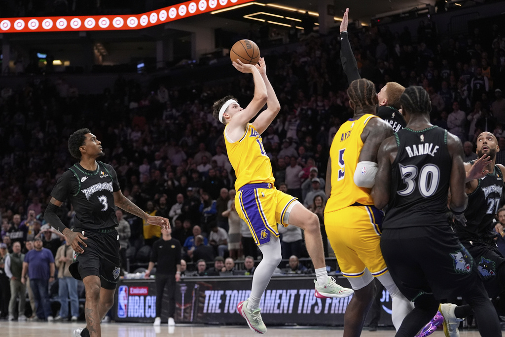 Los Angeles Lakers guard Austin Reaves, middle, shoots and scores the game-winning shot at the buzzer in an NBA basketball game against the Minnesota Timberwolves, Wednesday, Oct. 29, 2025, in Minneapolis. (AP Photo/Abbie Parr)