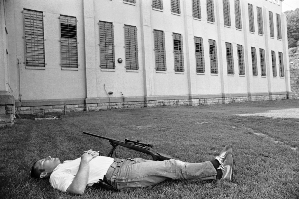 FILE - A sharpshooter at Brushy Mountain State Prison in Petros, Tenn., June 11, 1977, takes a nap on the lawn in front of a cellblock after duty in the search for six escaped convicts, including James Earl Ray. (AP Photo/Jack Thornell, File)
