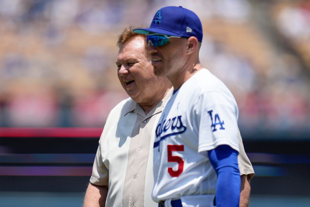 FILE - Los Angeles Dodgers first baseman Freddie Freeman (5) walks with his father, Fred Freeman, on the field before a baseball game against the San Francisco Giants in Los Angeles, June 18, 2023. (AP Photo/Ashley Landis, File)