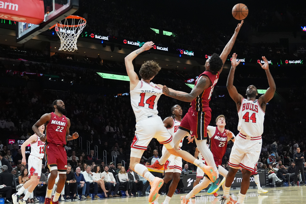 Miami Heat forward Myron Gardner (15) tries to control the ball as Chicago Bulls forward Matas Buzelis (14) and forward Patrick Williams (44) defend during the first half of an NBA basketball game, Saturday, Jan. 31, 2026, in Miami. (AP Photo/Lynne Sladky)