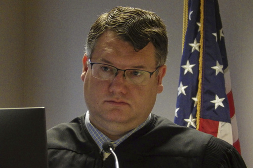North Dakota State District Judge Jackson Lofgren listens during a court hearing on March 31, 2025, at the Burleigh County Courthouse in Bismarck, N.D. (AP Photo/Jack Dura) North Dakota State District Judge Jackson Lofgren listens during a court hearing on March 31, 2025, at the Burleigh County Courthouse in Bismarck, N.D. (AP Photo/Jack Dura)