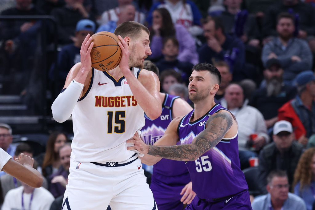 Denver Nuggets center Nikola Jokic (15) looks for a play against Utah Jazz guard John Konchar (55) during the first half of an NBA basketball game, Wednesday, April 1, 2026, in Salt Lake City. (AP Photo/Rob Gray)