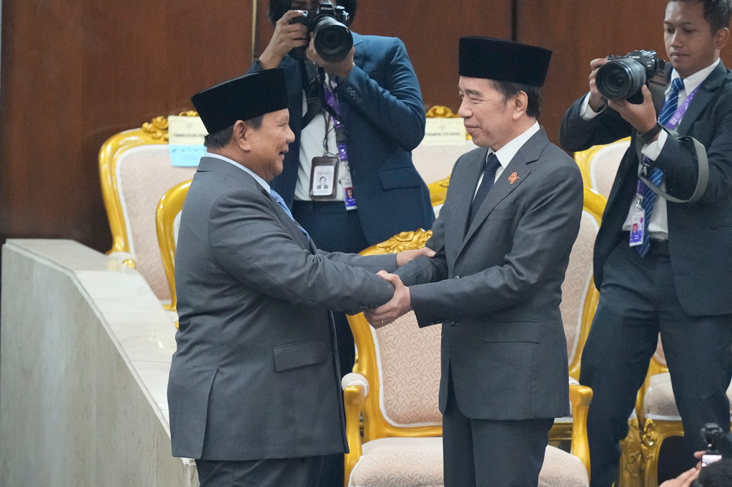Indonesian President Prabowo Subianto, left, shakes hands with former president Joko Widodo after delivering his State of the Nation address ahead of the country's Independence Day at the parliament building in Jakarta, Indonesia, Friday, Aug. 14, 2026. (AP Photo/Dita Alangkara)