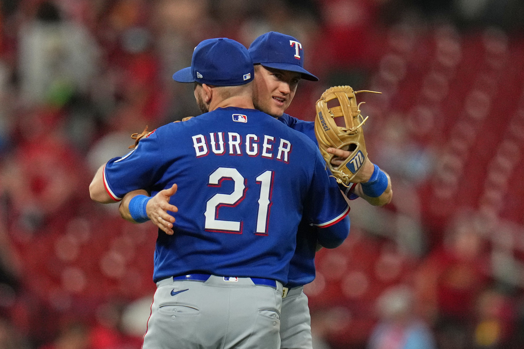 Texas Rangers' Jake Burger (21) and Josh Jung hug following a baseball game against St. Louis Cardinals Tuesday, June 2, 2026, in St. Louis. (AP Photo/Jeff Roberson)