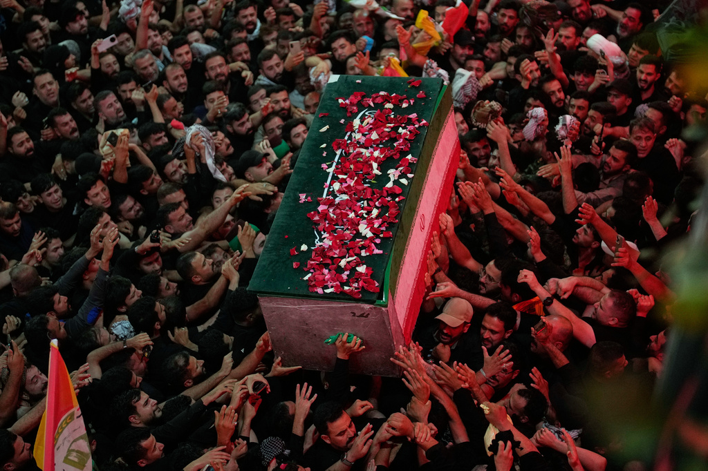 The coffin of the late Iranian Supreme Leader Ayatollah Ali Khamenei, covered with flower petals, is carried by mourners outside the Imam Hussein Shrine in Karbala, Iraq, early Thursday, July 9, 2026. (AP Photo/Khalil Hamra)