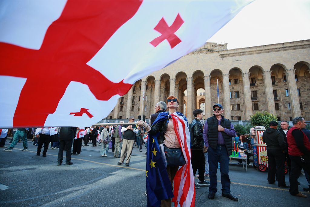 Opposition supporters with Georgian national and a U.S. national flags gather in the city center of Tbilisi, Georgia, on Saturday, Oct. 4, 2025, boycotting the municipal elections and call for the release of political opponents. (AP Photo/Zurab Tsertsvadze)