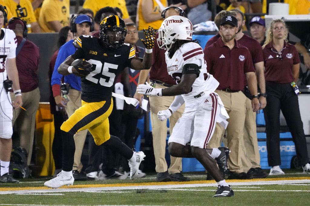 Iowa running back Nathan McNeil (25) runs from Massachusetts safety Zeraun Daniel after catching a pass during the second half of an NCAA college football game, Saturday, Sept. 13, 2025, in Iowa City, Iowa. (AP Photo/Charlie Neibergall)