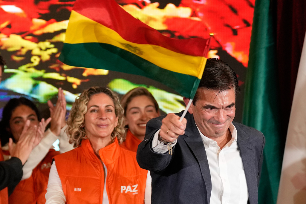FILE - Presidential candidate Rodrigo Paz waves a Bolivian flag after preliminary results showed him leading in the presidential runoff election in La Paz, Bolivia, Oct. 19, 2025. (AP Photo/Natacha Pisarenko, File)