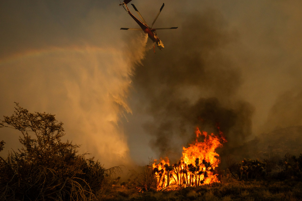 A helicopter drops water on the Summit Fire in Llano, CA. Friday, July 10, 2026. (AP Photo/Ethan Swope)