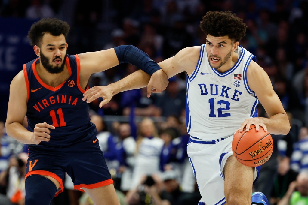 Duke forward Cameron Boozer (12) brings the ball upcourt against Virginia forward Devin Tillis during the first half of an NCAA college basketball game in the championship of the Atlantic Coast Conference tournament in Charlotte, N.C., Saturday, March 14, 2026. (AP Photo/Nell Redmond)
