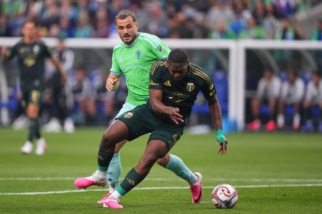 Seattle Sounders forward Jordan Morris, back, vies for the ball against Portland Timbers defender Kamal Miller, front, during the first half of an MLS soccer match, Thursday, July 16, 2026, in Seattle. (AP Photo/Lindsey Wasson)