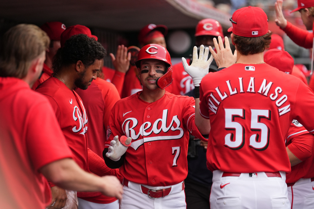Cincinnati Reds' Spencer Steer, center, is congratulated in the dugout after hitting a two-run home run during the first inning of a baseball game, Tuesday, April 28, 2026, in Cincinnati. (AP Photo/Kareem Elgazzar)