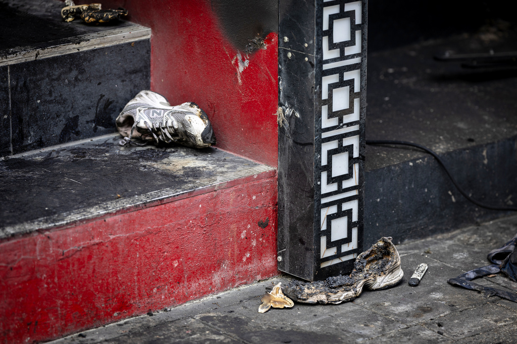 Burnt shoes are left outside the music bar where a fire killed a number of people in Bangkok, Thailand, Tuesday, July 14, 2026. (AP Photo/Wason Wanichakorn)