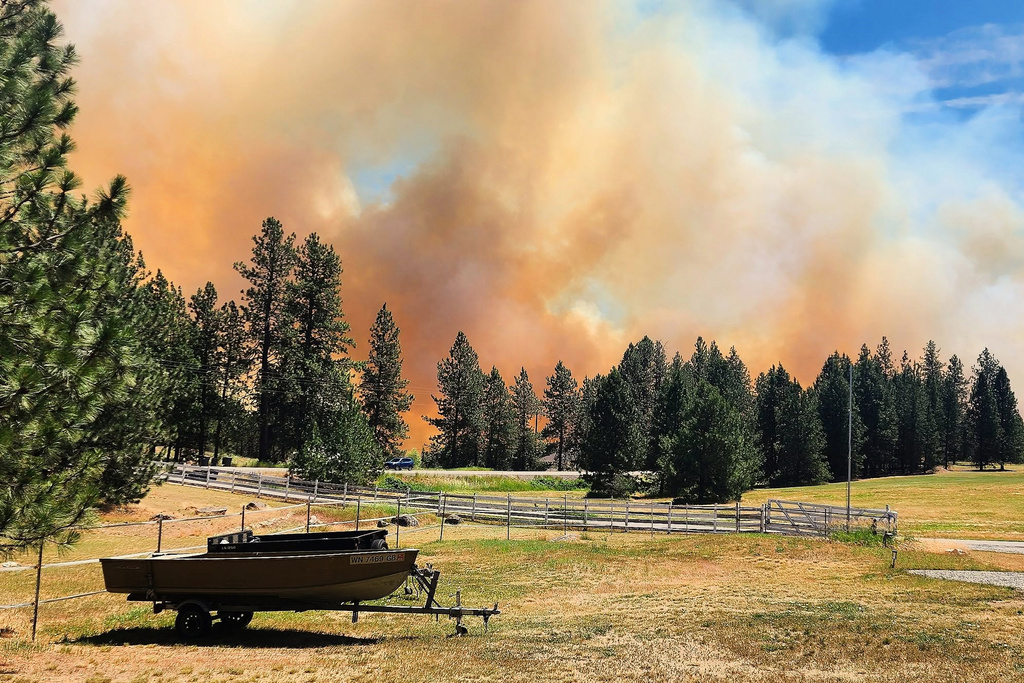 This photo provided by Scott Crawford shows the Upriver Fire sending a plume of smoke in the air on Tuesday, June 16, 2026 near Spokane, Wash. (Scott Crawford via AP)