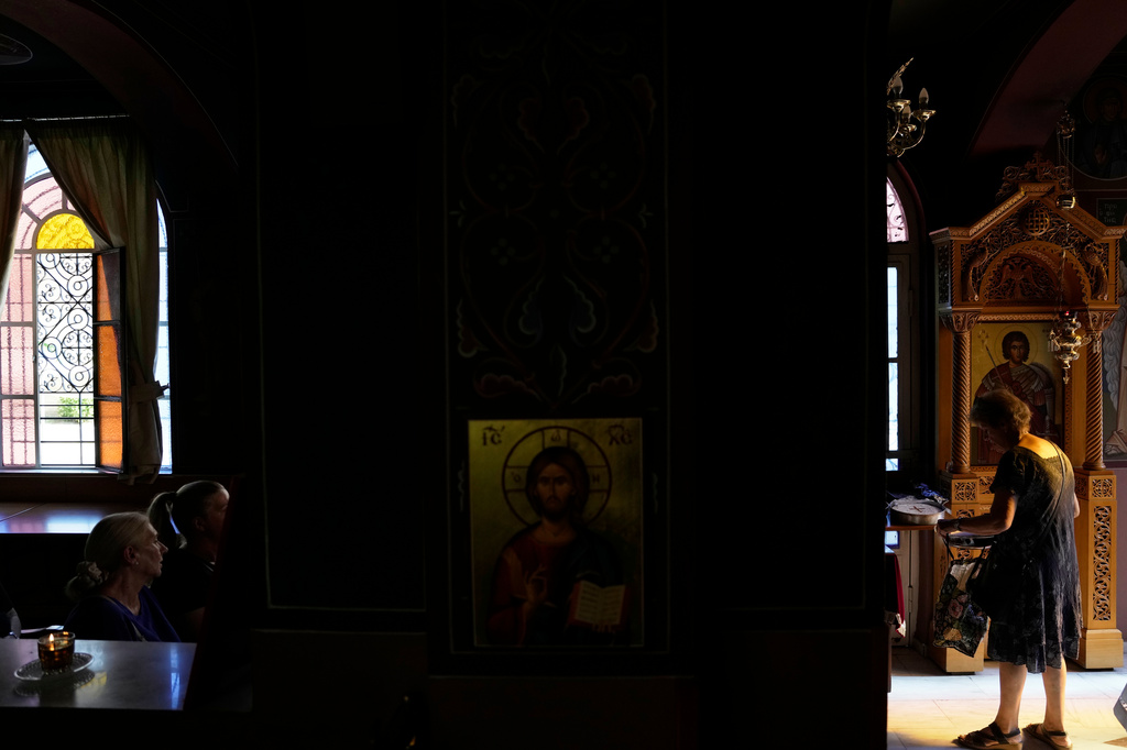 Pilgrims wait to have their Fanouropites, orange-flavored cakes, blessed at the Church of St. Fanourios in Athens, Tuesday, Aug. 25, 2026. (AP Photo/Thanassis Stavrakis)