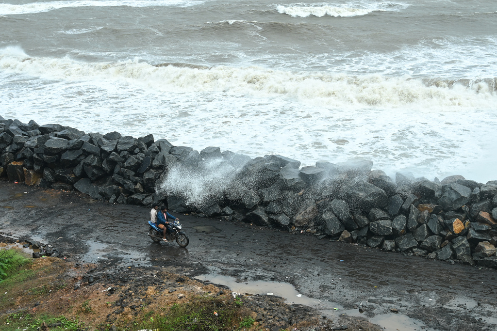 A motorist drives past boulders recently installed along the coastline to protect against high tides during Cyclone Montha, in Kakinada district of Andhra Pradesh, India, Tuesday, Oct. 28, 2025. (AP Photo)