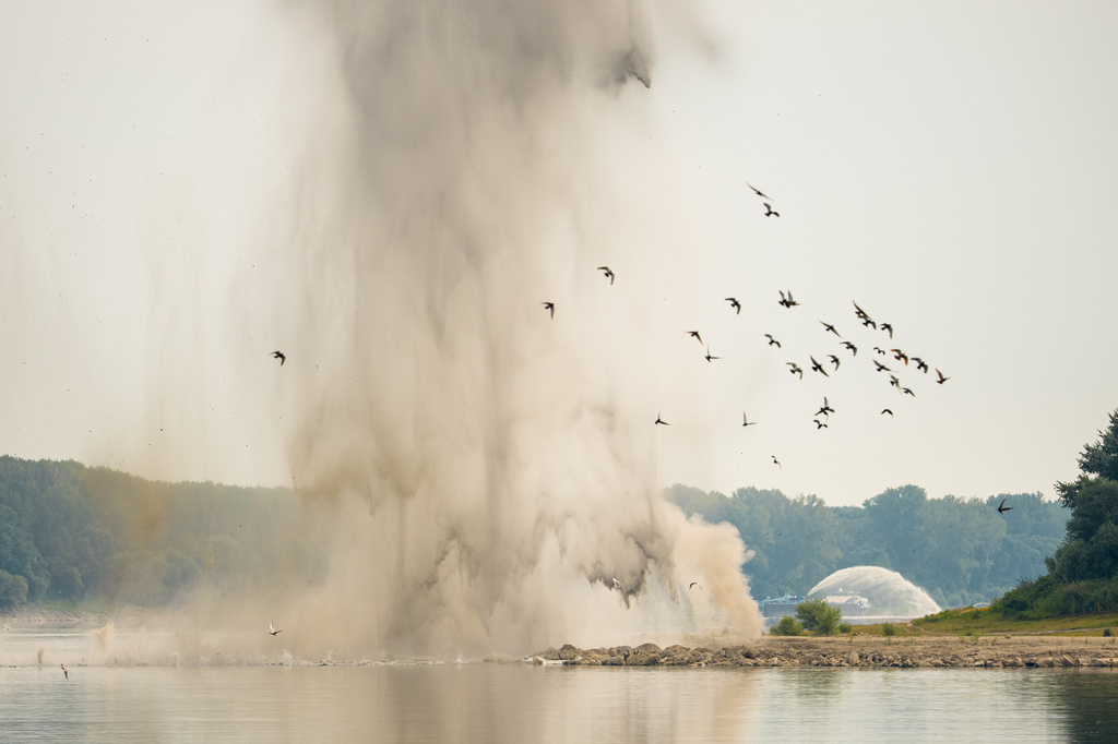 Birds fly after a controlled demolition by the Romanian Navy of submerged rocks to improve water flow to the Cernavoda Nuclear Power Plant amid exceptionally low water levels on the Danube River, in Izvoarele, Romania, Monday, Aug. 3, 2026. (AP Photo/Vadim Ghirda)