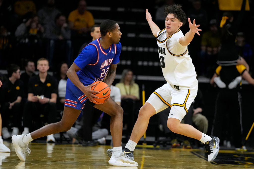UMass-Lowell guard Khalil Farmer (22) looks to pass around Iowa guard Isaia Howard during the first half of an NCAA college basketball game, Monday, Dec. 29, 2025, in Iowa City, Iowa. (AP Photo/Charlie Neibergall)