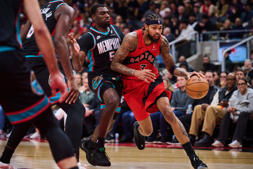Toronto Raptors' Brandon Ingram (3) drives past Memphis Grizzlies' Vince Williams Jr. (5) during first-half NBA basketball game action in Toronto, Sunday, Nov. 2, 2025. (Sammy Kogan/The Canadian Press via AP)