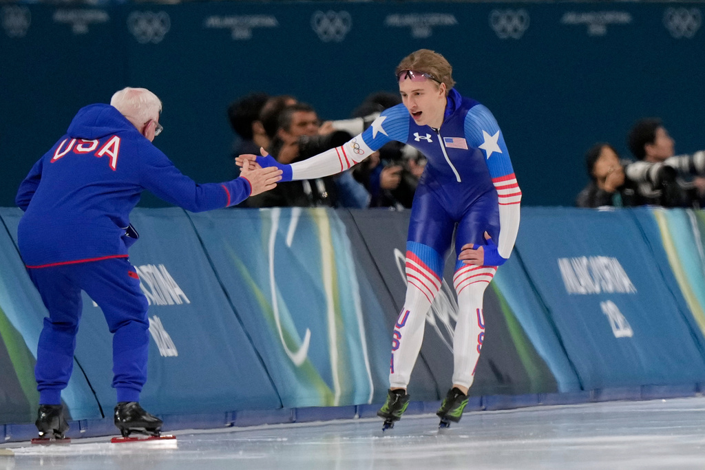 Jordan Stolz of the U.S. celebrates with his catch Bob Corby, left, after the men's 1,000 meters speedskating race at the 2026 Winter Olympics, in Milan, Italy, Wednesday, Feb. 11, 2026. (AP Photo/Luca Bruno)