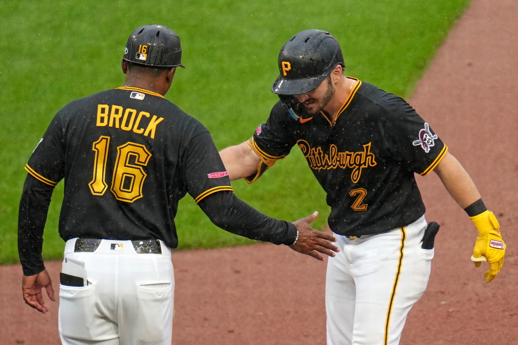 Pittsburgh Pirates' Spencer Horwitz (2) celebrates with first base coach Tarrik Brock (16) after driving in a run with a single off Kansas City Royals pitcher Michael Wacha during the sixth inning of a baseball game in Pittsburgh, Sunday, Sept. 20, 2026. (AP Photo/Gene J. Puskar)