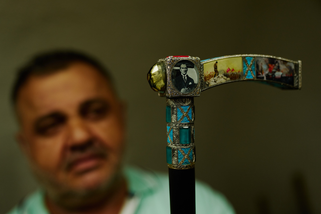 Master inlay and relief craftsman Sahin Karaman holds one of his pieces, an ornately decorated walking stick, in his workshop in the Buyukhan artisan quarter in Istanbul, Turkey, Thursday, Aug. 6, 2026. (AP Photo/Francisco Seco)