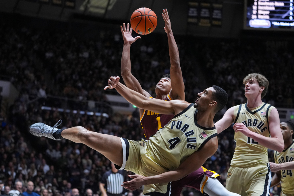 Purdue forward Trey Kaufman-Renn (4) and Minnesota guard Isaac Asuma (1) go for a rebound during the first half of an NCAA college basketball game in West Lafayette, Ind., Wednesday, Dec. 10, 2025. (AP Photo/Michael Conroy)