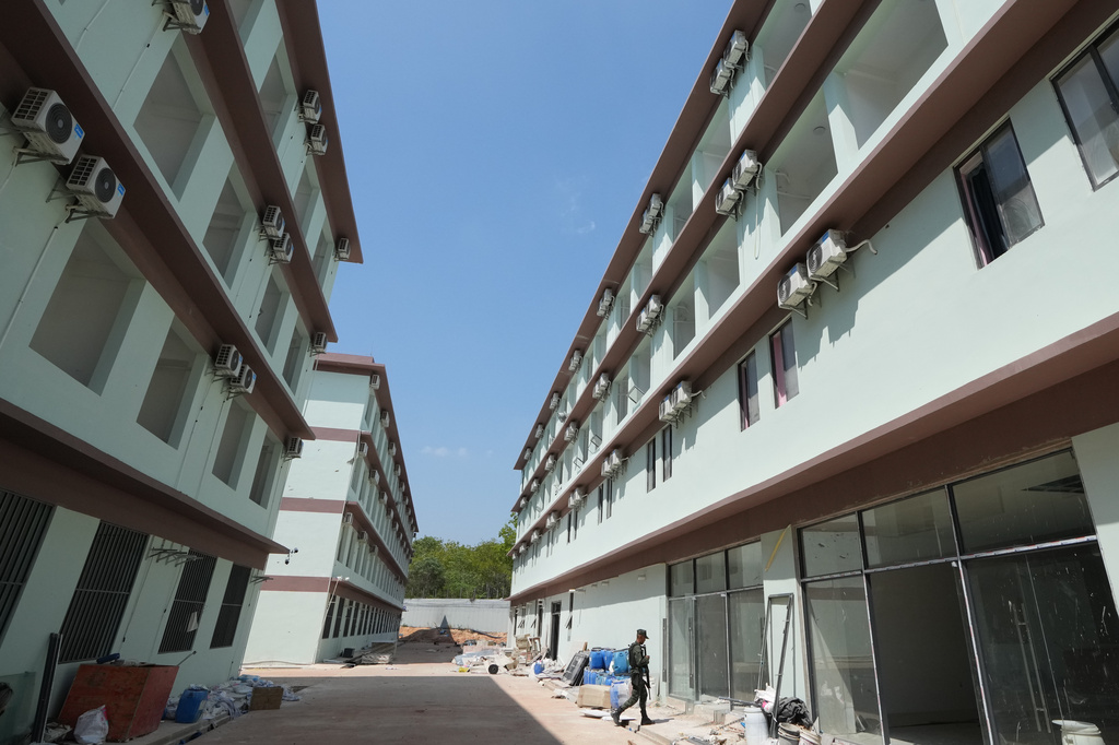 A Thai soldier guards outside the scam compound in O'Smach, Cambodia, Tuesday, April 7, 2026. (AP Photo/Sakchai Lalit)