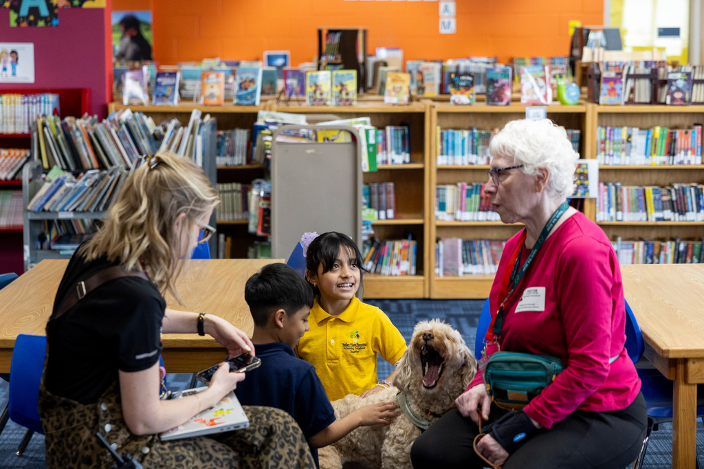 Yesli, center right, pets Sage, a therapy dog, at Valley View Elementary School on April 29, 2026, in Columbia Heights, Minn. (Ellen Schmidt/MinnPost via AP)