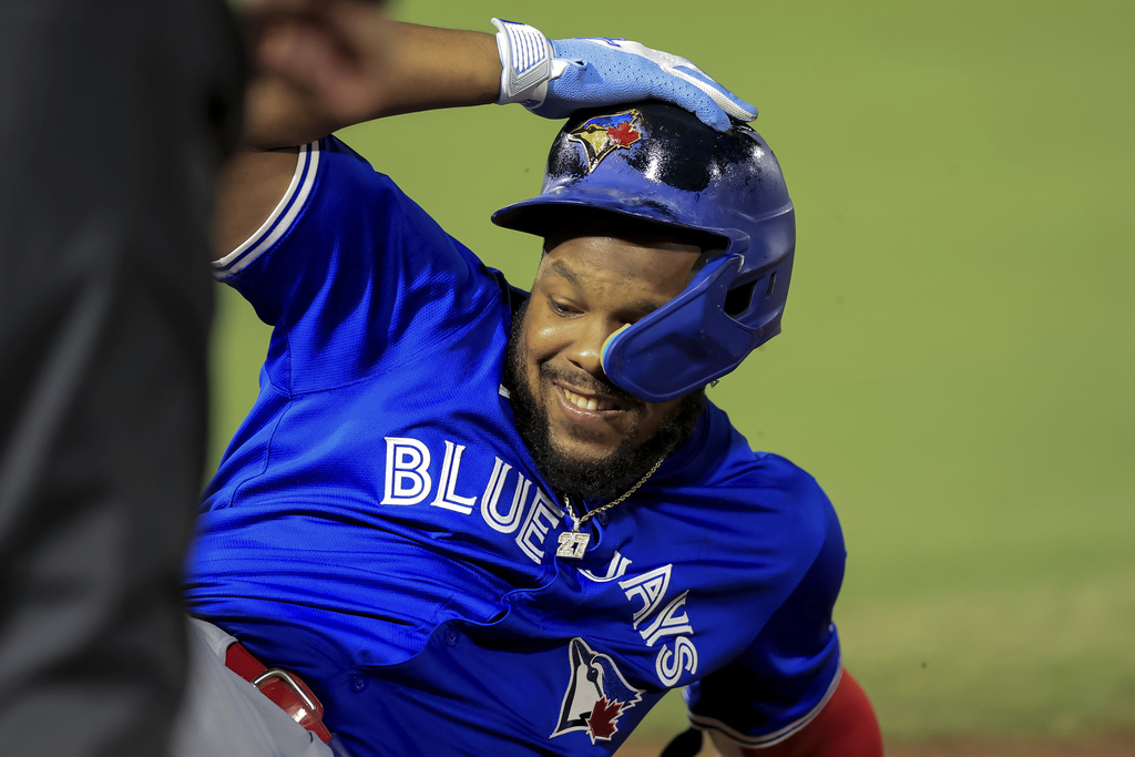 Toronto Blue Jays' Vladimir Guerrero Jr. slides back into first base after his run-scoring single against the Tampa Bay Rays during the second inning of a baseball game Tuesday, Sept. 16, 2025, in Tampa, Fla. (AP Photo/Mike Carlson)