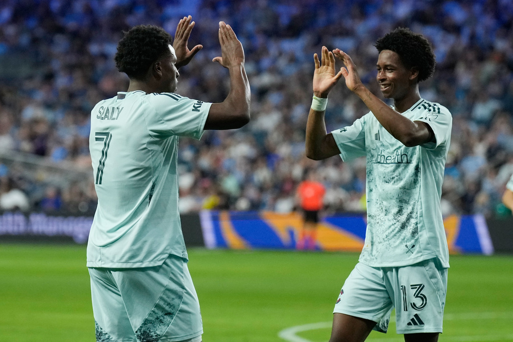 Colorado Rapids forward Wayne Frederick (13) celebrates with forward Dante Sealy (7) afte scoring a goal during the first half of an MLS soccer match against Sporting Kansas City, Saturday, March 21, 2026, in Kansas City, Kan. (AP Photo/Charlie Riedel)