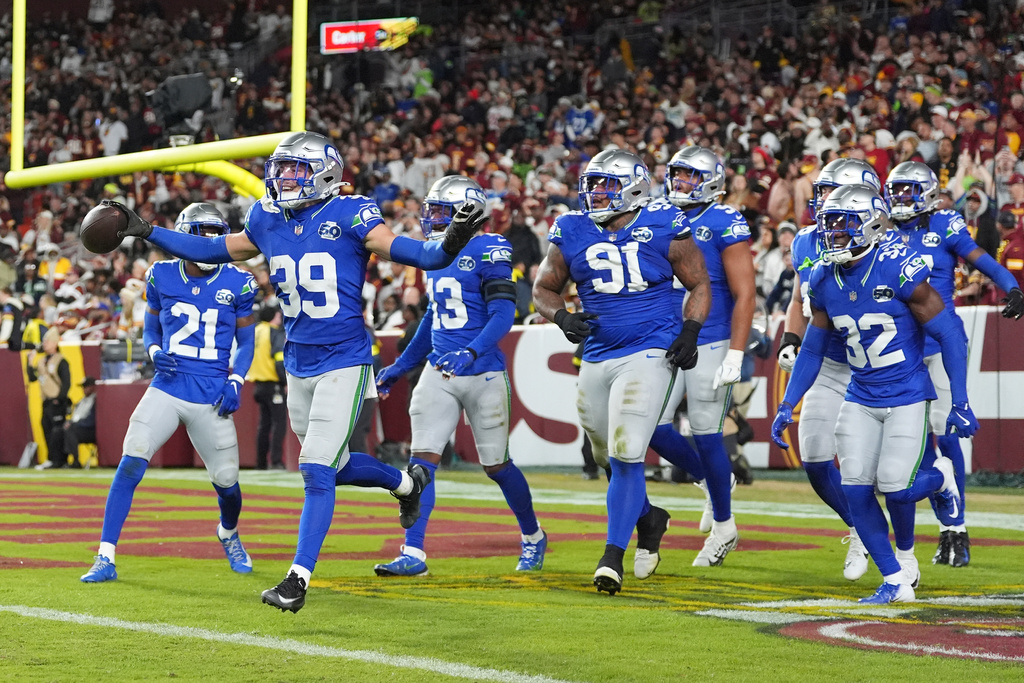 Seattle Seahawks safety Ty Okada (39) celebrating his interception with teammates during the first half of an NFL football game against Washington Commanders, Sunday, Nov. 2, 2025, in Landover, Md. (AP Photo/Stephanie Scarbrough)
