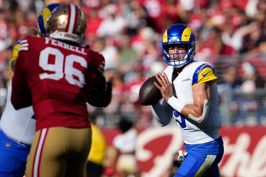 Los Angeles Rams quarterback Matthew Stafford, right, rolls out to pass against the San Francisco 49ers during the first half of an NFL football game in Santa Clara, Calif., Sunday, Nov. 9, 2025. (AP Photo/Godofredo A. Vásquez)