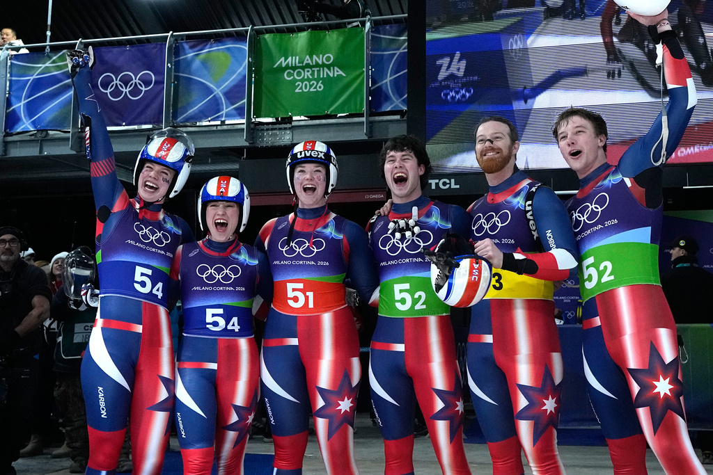 United States' Sophia Kirkby, Marcus Mueller, Jonathan Gustafson, Chevonne Forgan, Ashley Farquharson and Ansel Haugsjaa celebrate during the luge relay competition at the 2026 Winter Olympics, in Cortina d'Ampezzo, Italy, Thursday, Feb. 12, 2026. (AP Photo/Alessandra Tarantino)