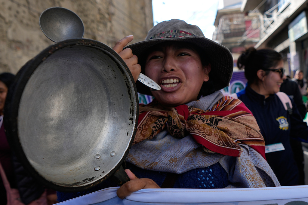 A teacher holds an empty pot during an anti-government protest in La Paz, Bolivia, Tuesday, Sept. 15, 2026. (AP Photo/Juan Karita)