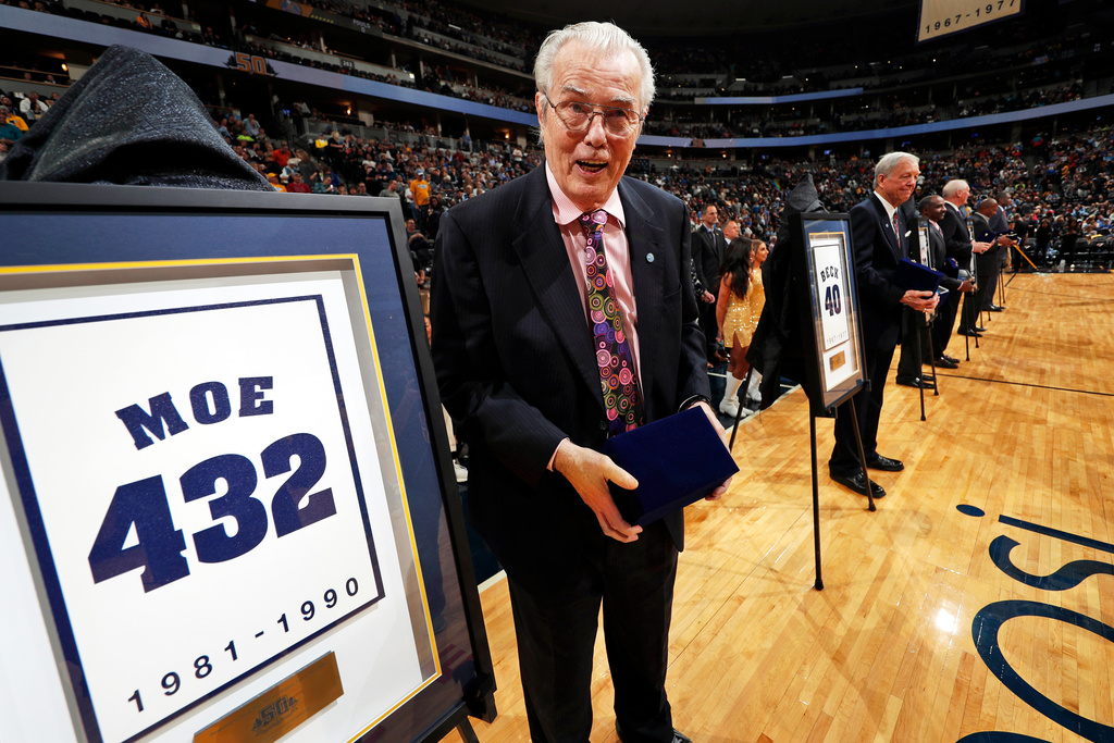 FILE - Retired Denver Nuggets head coach Doug Moe stands next to his retired number during the team's 50th anniversary celebration before the second half of an NBA basketball game, Oct. 21, 2017, in Denver. (AP Photo/David Zalubowski, File)
