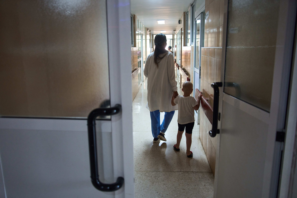 FILE - Nashly Zerquera, a 4-year-old oncology patient, walks with Dr. Yolainy Romero Rodriguez at the National Institute of Oncology and Radiobiology in Havana, Cuba, June 24, 2026. (AP Photo/Ramon Espinosa, File)