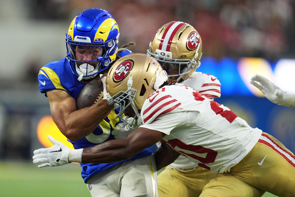 Los Angeles Rams wide receiver Jordan Whittington, left, runs against San Francisco 49ers cornerback Upton Stout, bottom right, during the first half of an NFL football game, Thursday, Oct. 2, 2025, in Inglewood, Calif. (AP Photo/Marcio Jose Sanchez)