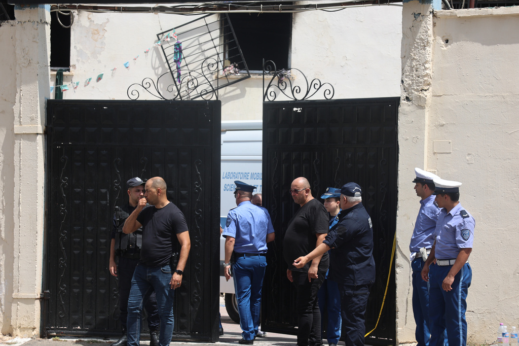 Policemen stand outside the fire damaged orphanage in Mohammedia, near Algiers, Algeria, Thursday, July 16, 2026. (AP Photo)