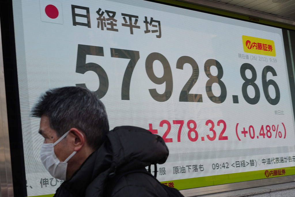 A person walks in front of an electronic stock board showing Japan's Nikkei index at a securities firm Thursday, Feb. 12, 2026, in Tokyo. (AP Photo/Eugene Hoshiko)